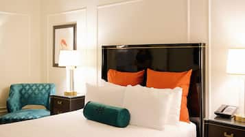 Una habitación de hotel con una cama, una mesita de noche con un teléfono, una silla y una lámpara.