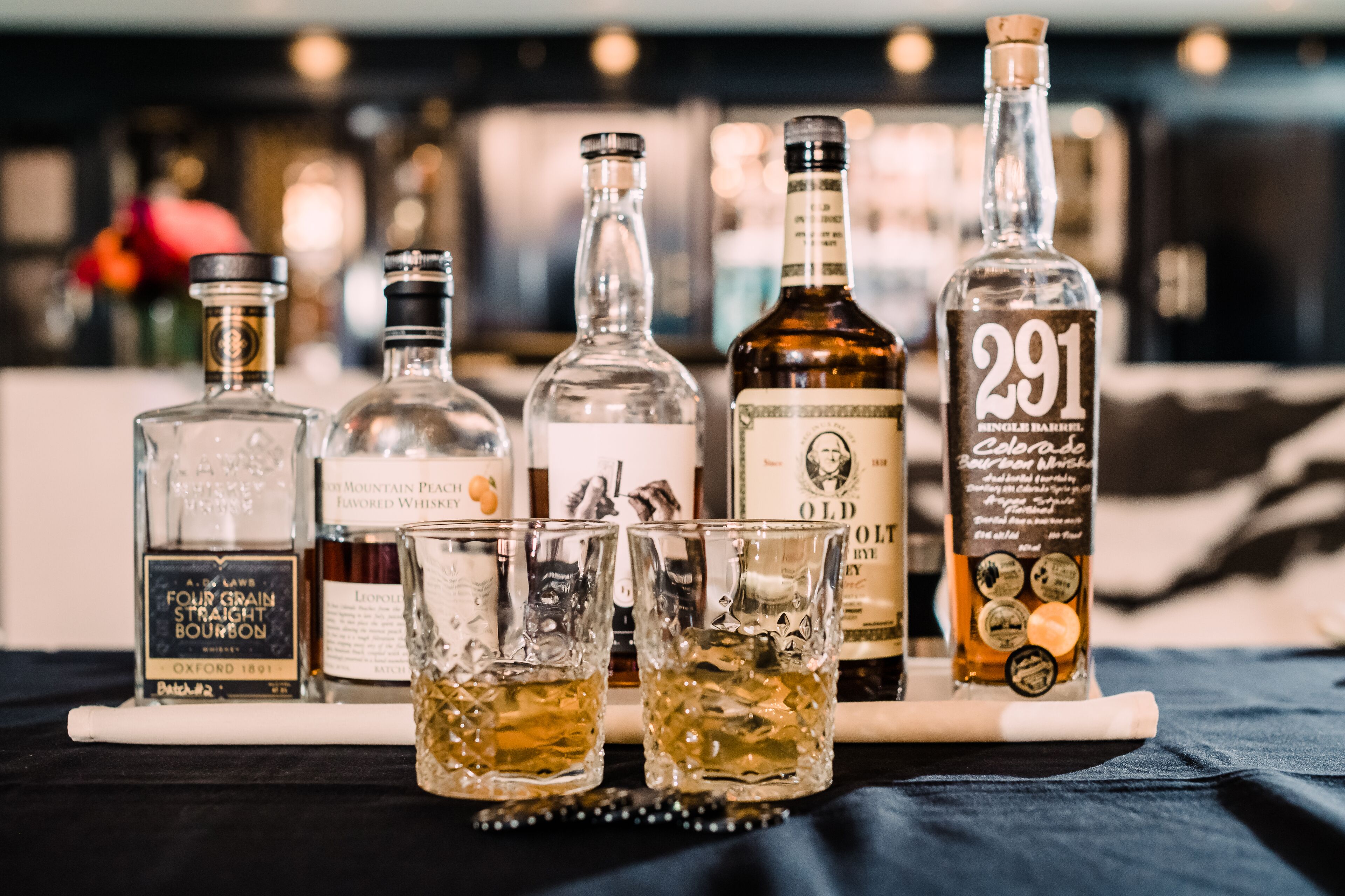 A selection of liquor bottles and glasses on a bar counter.