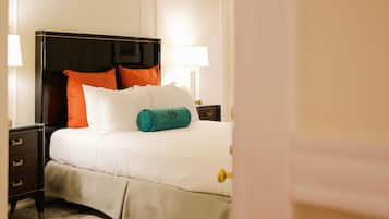 A neatly made bed with a headboard, two bedside tables, and a lamp.