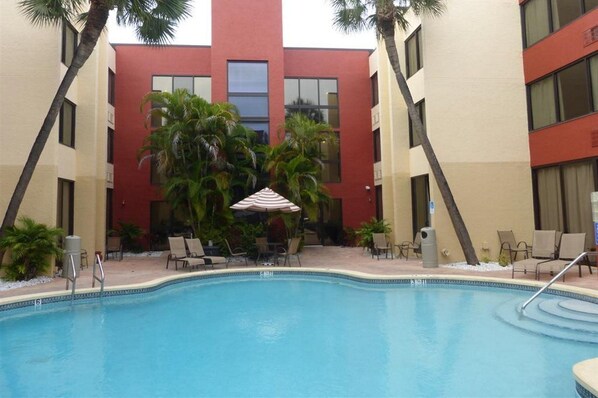 Alberca al aire libre, sombrillas en la alberca y camastros 