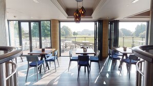 Un comedor amplio con ventanas grandes, muebles modernos y vistas al exterior.