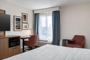 A hotel room with a bed, a desk, a chair, a television, and a window with curtains. - Hampton Inn Owensboro South (Owensboro)