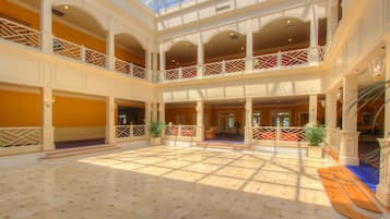 Un vaste atrium doté d’un haut plafond, de nombreux balcons et d’un espace central ouvert avec un sol à motifs.