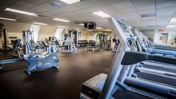 A gym with treadmills, weight machines, and a variety of exercise equipment.