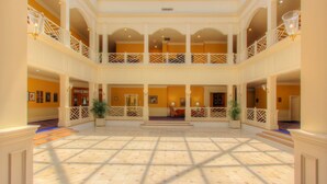 A spacious atrium with a high ceiling, multiple balconies, and a central seating area. - The Founders Inn and Spa, Tapestry Collection by Hilton (Virginia Beach)