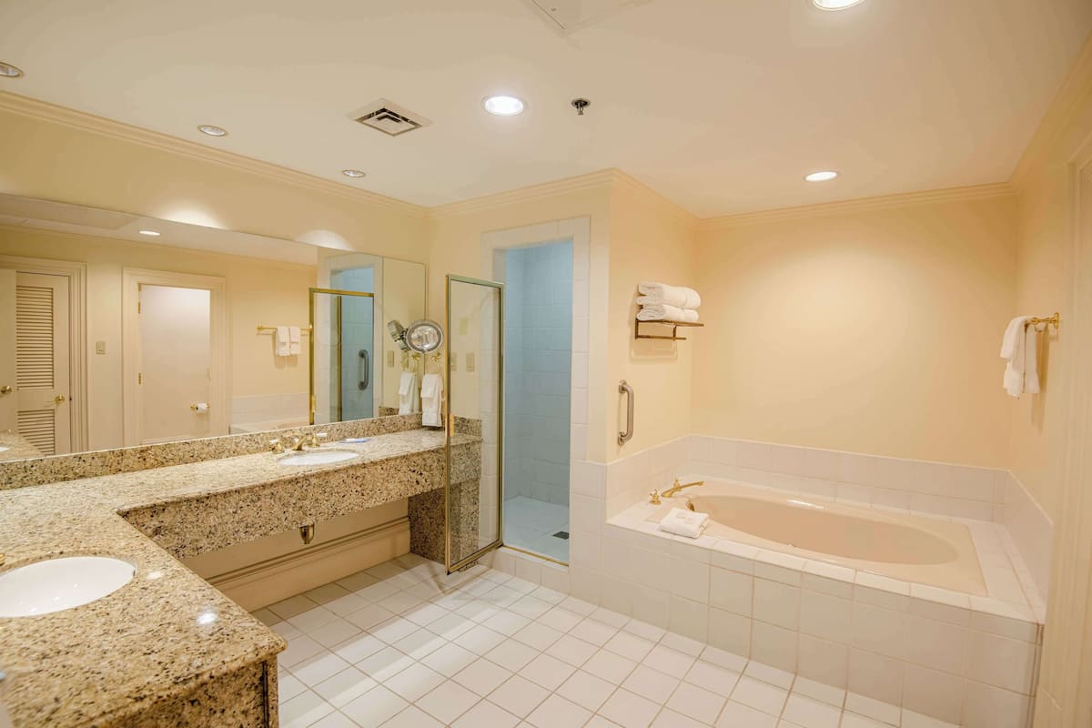 A modern bathroom with a double sink vanity, a walk-in shower, and a standalone bathtub.