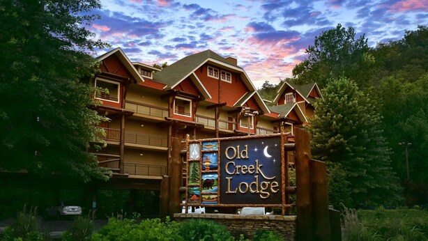 Een lodge met een opvallend bord waarop 'Old Creek Lodge' staat, en een prachtig uitzicht op de lucht.