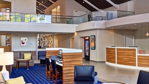 A spacious lobby with a reception desk, seating area, and a vending machine. - Sonesta Simply Suites Memphis East Poplar Pike ​ (Memphis)