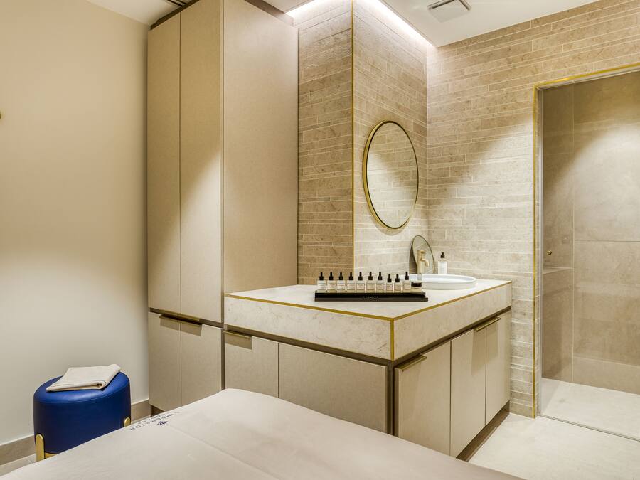A modern bathroom with a marble vanity, a large mirror, and a shower area.