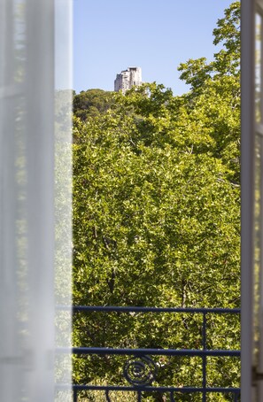 Guests can enjoy a serene view of a lush tree-lined area from the comfort of their room.