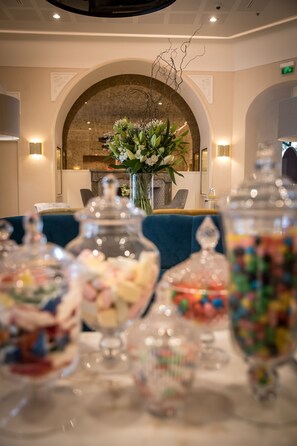Enjoy a beautifully set table in our dining area, complete with a vase of flowers and elegant decor.