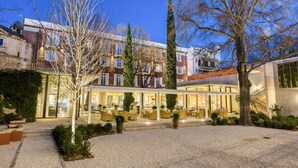 A hotel courtyard with outdoor seating, a covered area, and a gravel path.