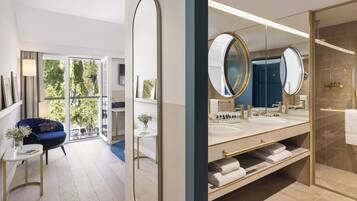 A modern bathroom with a large mirror, dual sinks, and a glass shower enclosure.
