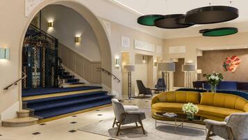 Un intérieur moderne avec un escalier, un canapé jaune et une table basse.