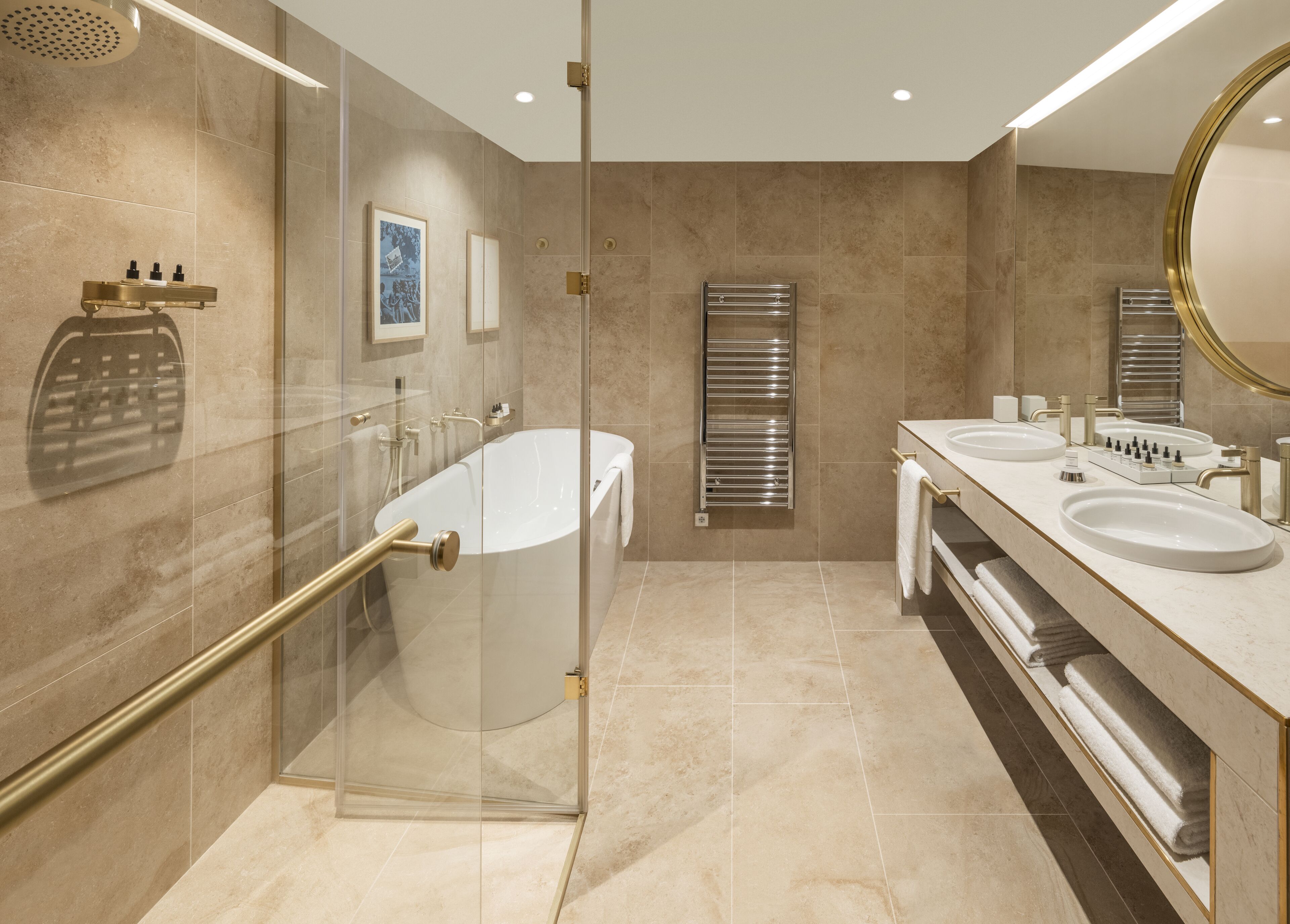 Ein modernes Badezimmer mit einer gläsernen Duschkabine, einer freistehenden Badewanne und einem Waschtisch mit zwei Waschbecken.