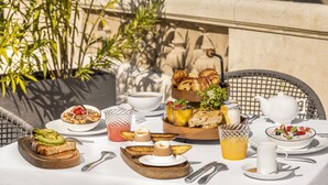 A table set for breakfast with various dishes, including toast, pastries, and fruit.