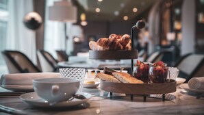A breakfast setting with croissants, fruit, and a cup on a table.
