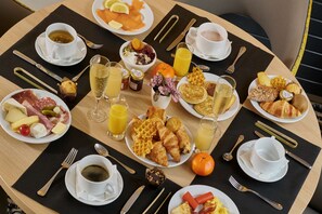 A breakfast table with various dishes, drinks, and utensils. - Best Western Plus Hotel Carlton (Annecy)