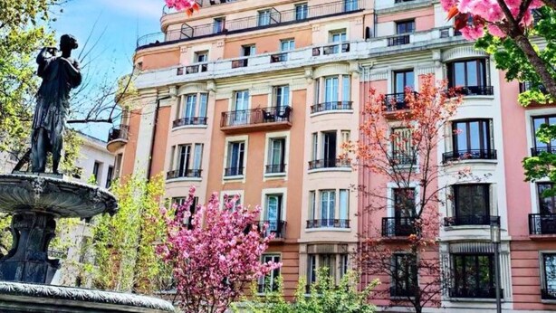Un hotel con fachada clásica, varios balcones y una vista despejada del cielo.