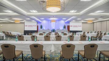 Una sala conferenze con tavoli e sedie, un palco con tende e striscioni per Crowne Plaza Hotels & Resorts.