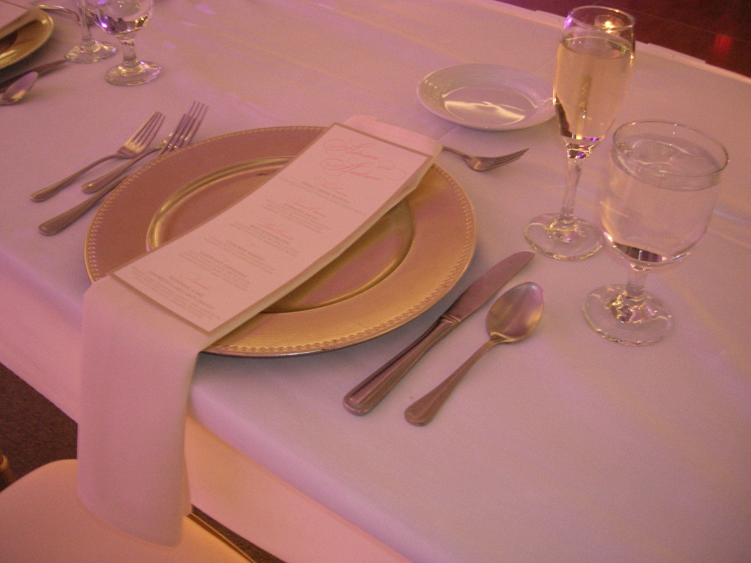 A table set with a menu, cutlery, and glasses, likely in a dining area.