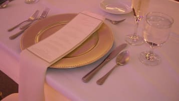 A table set with a menu, cutlery, and glasses, likely in a dining area.