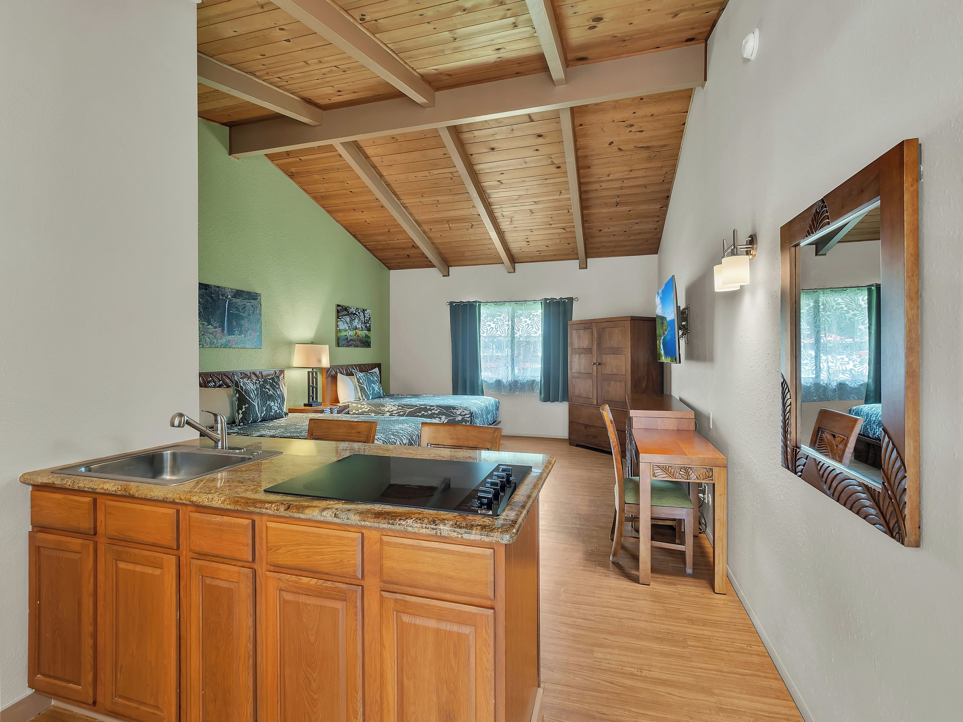 Cocina compacta con armarios de madera, una isla central y una zona de comedor con sillas.