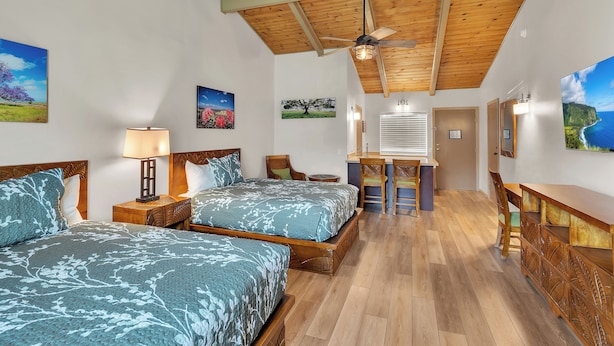 A room with two beds, a desk, and a ceiling fan. - Castle Waimea Country Lodge (Kamuela)