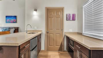 Una cocina con un lavamanos doble, armarios de madera, un refrigerador de acero inoxidable y techo de madera.
