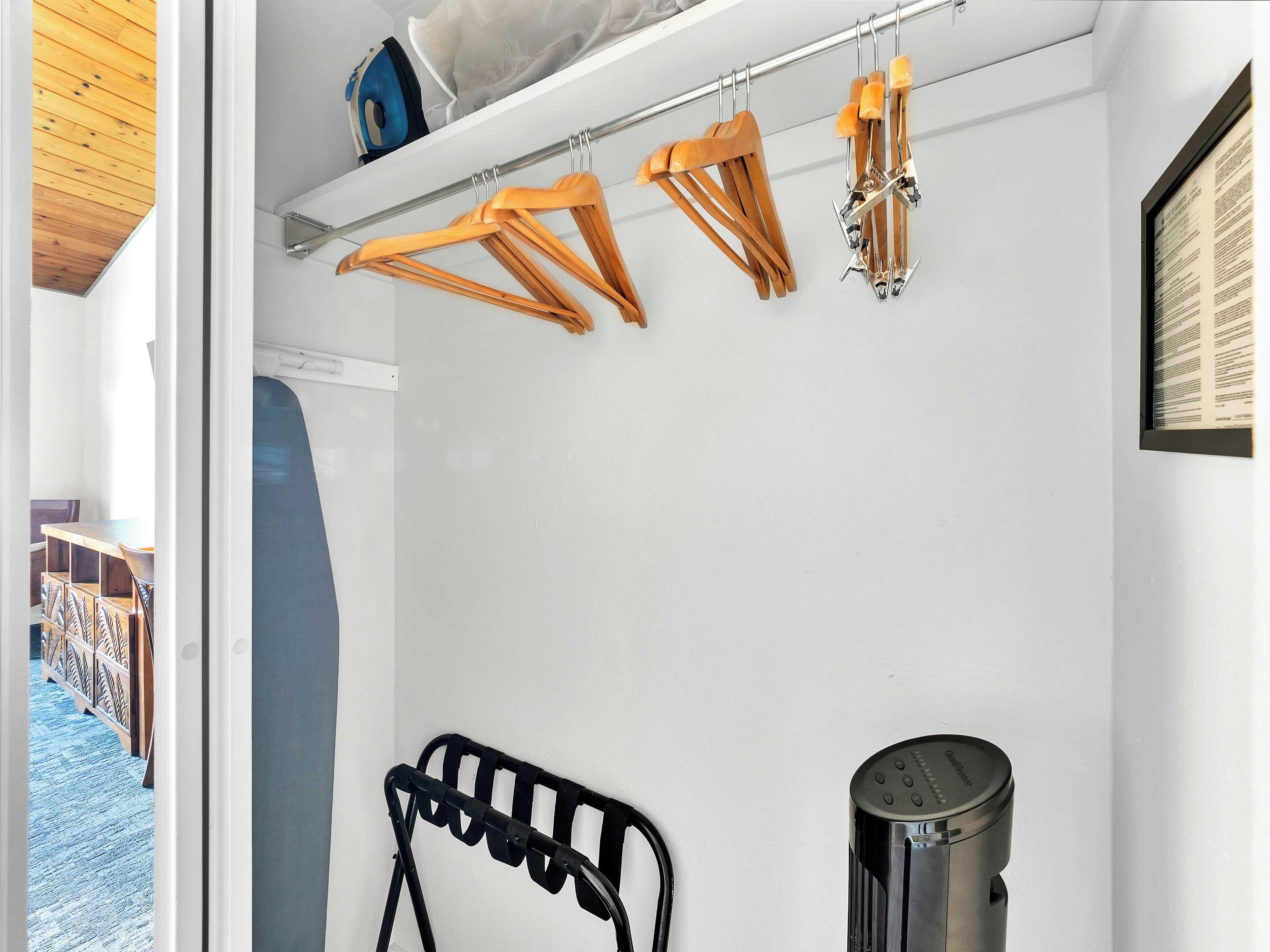 Una habitación con pared blanca, una silla negra y un electrodoméstico metálico.