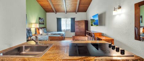 A kitchen with granite countertops, wooden cabinets, a sink, and a stove.