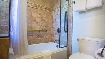 A bathroom with a bathtub, a glass-enclosed shower, and a toilet.