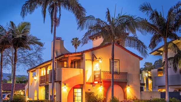 A two-story building with a balcony, palm trees, and a sign that reads "Castillo Inn." - Castillo Inn at the Beach (Santa Barbara)