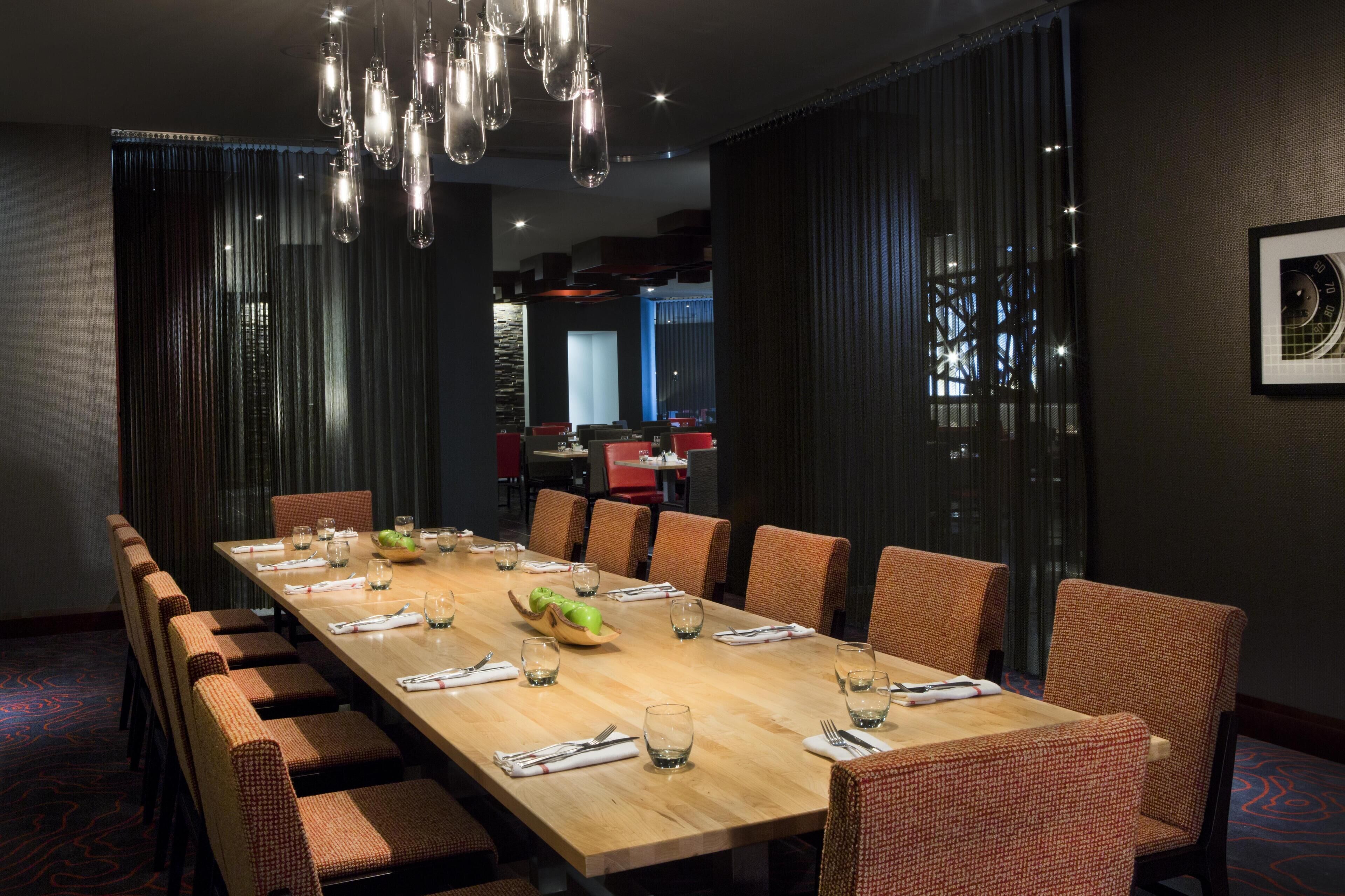 A conference room with a long table, chairs, and a chandelier.