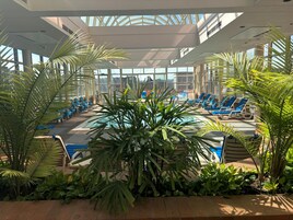 Una piscina techada, sillones reclinables de piscina