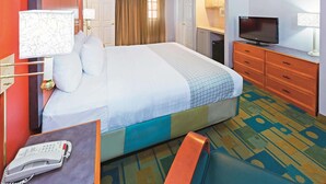 A hotel room with a large bed, a television, a desk with a lamp, and a telephone. - Baymont by Wyndham Lubbock - Downtown Civic Center (Lubbock)