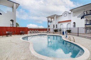 A swimming pool with lounge chairs and a red fence. - SureStay Hotel by Best Western Spring North Houston (Spring)