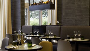 A restaurant with round tables, chairs, and a seating area with a bench. - Best Western Plus Hotel Du Parc Chantilly (Chantilly)