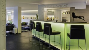 Ein moderner Lounge-Bereich mit Barhocker, einer Bar und einer Sitzecke mit Sofas.