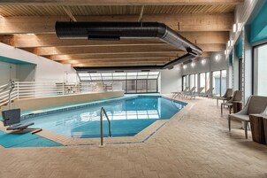 Una piscina al aire libre de temporada, sillones reclinables de piscina