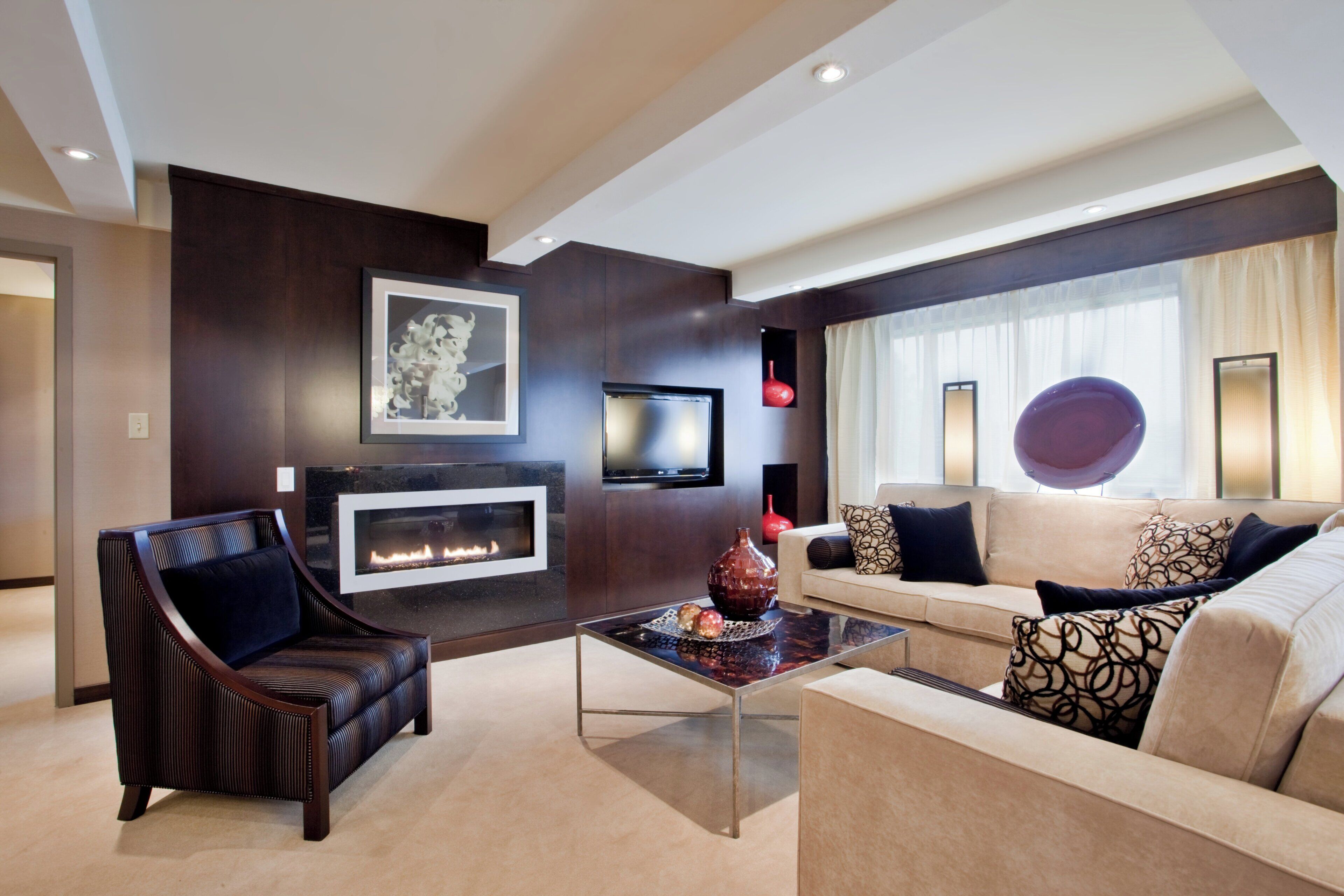 A modern living room with a fireplace, a sofa, a chair, and a coffee table.