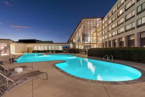 Una piscina al aire libre de temporada, tumbonas