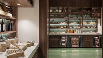 A well-organized kitchen with wooden shelves, a marble countertop, and a green-tiled backsplash.