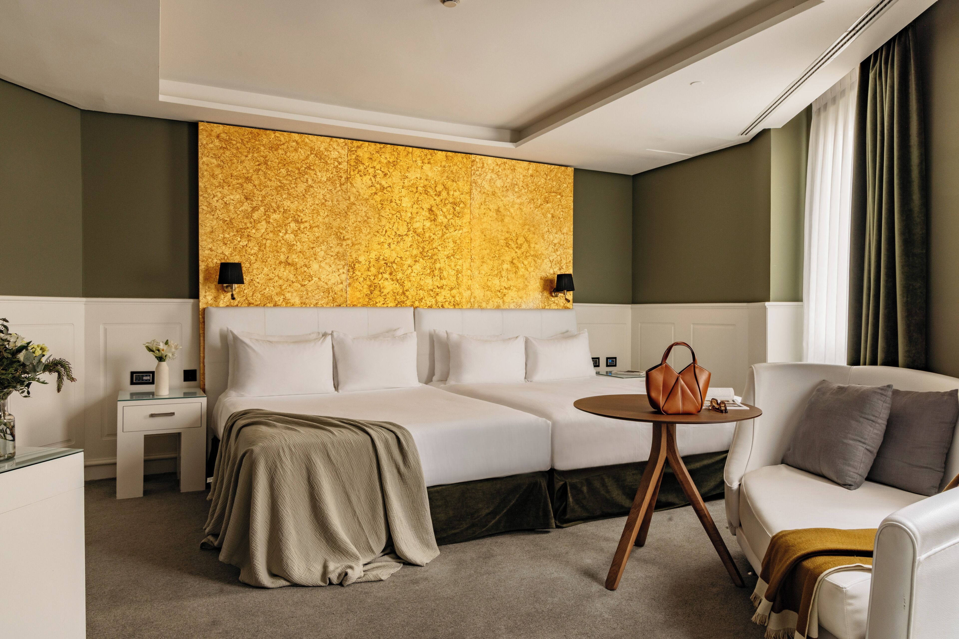 Una habitación de hotel con una cama, un sofá, una mesita y una decoración de pared.