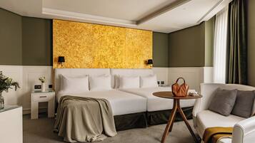 Una habitación de hotel con una cama, un sofá, una mesita y una decoración de pared.