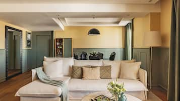A living room with a sofa, a coffee table with a book and vase, a mirror, and a ceiling light.