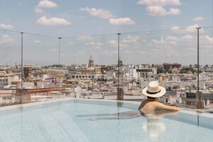 Una piscina al aire libre, sillones reclinables de piscina