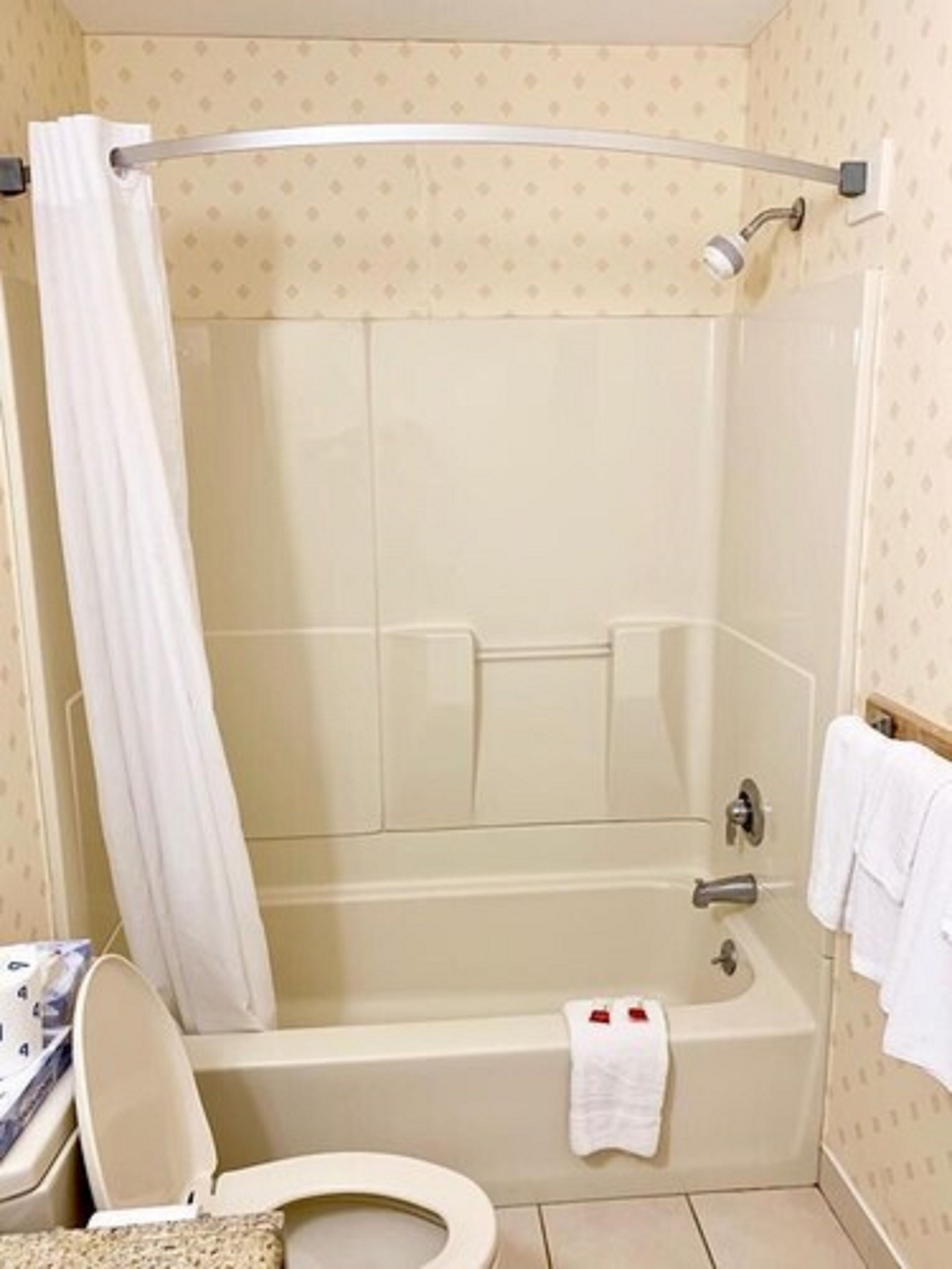 Un baño con bañera, inodoro y cortina de ducha.