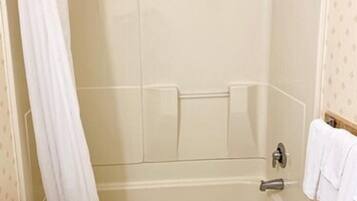 Un baño con bañera, inodoro y cortina de ducha.