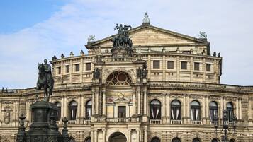 A historic building with classical architecture, featuring a central pediment, multiple statues, and a prominent entrance.